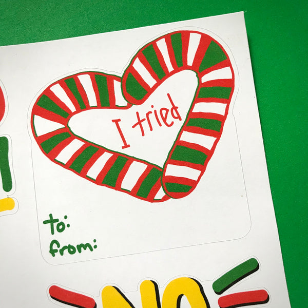 A close up image of a sticker tag with the words I TRIED inside a heart made of two candy canes, with to: from: at the bottom