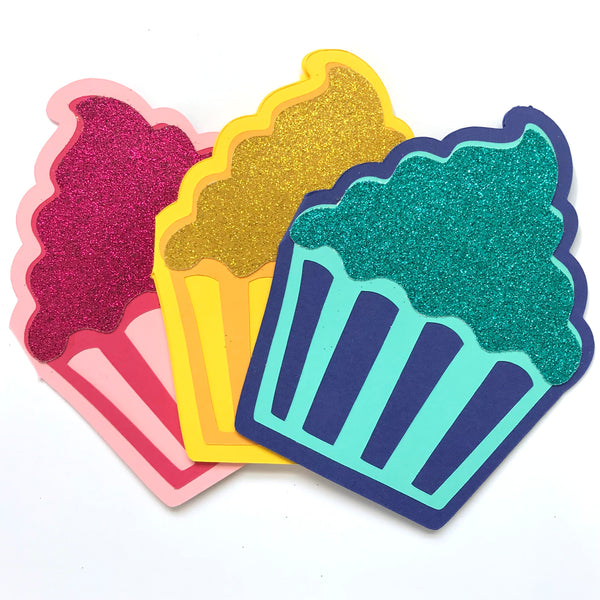 three cupcake shaped cards are shown against a white background.  The cupcakes are coloured, from left to right, pinks, yellows, and blues.