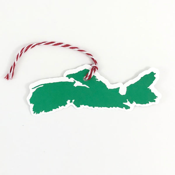 a single paper gift tag in green and white, in the shape of the province of Nova Scotia, is shown against a white background.  The tag has a red and white string attached to the top