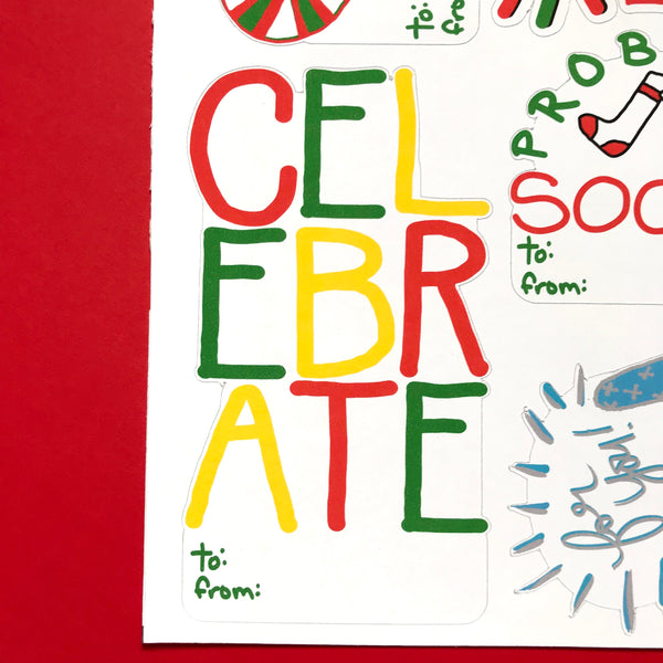 A close up image of the corner of the Festive sticker tag sheet against a red background.  The sticker tag shown reads CELEBRATE with a little to/from at the bottom.