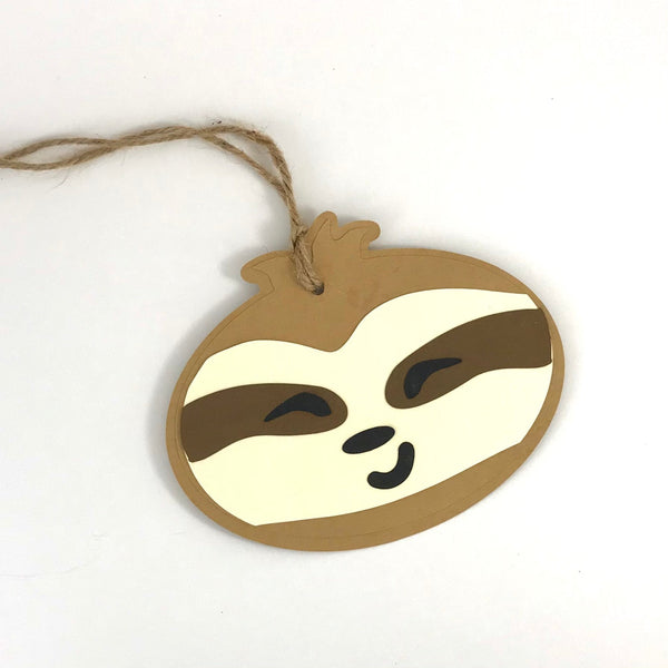 a smiling sloth face gift tag is shown against a white background