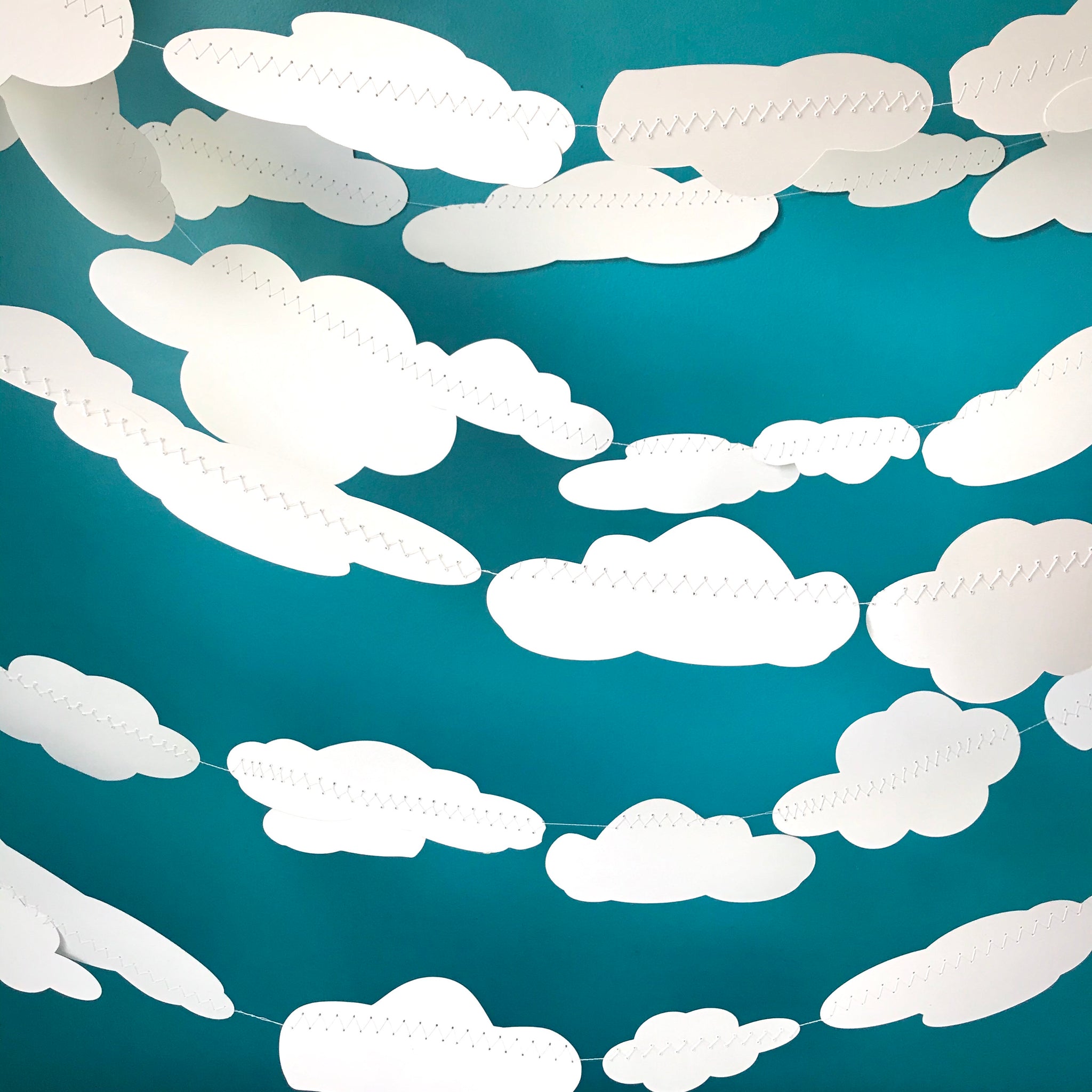 Dozens of white cloud shapes are shown against a blue background.