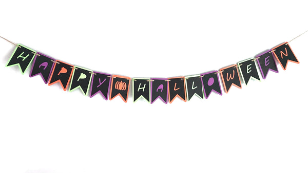 A paper banner reading Happy Halloween is shown against a white background.  There is a little pumpkin spacer piece between the word Happy and Halloween