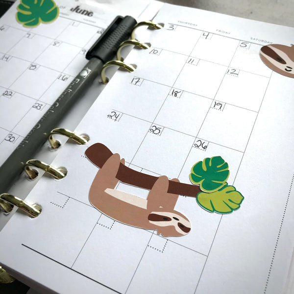 An agenda is shown with some sloth stickers decorating the pages.